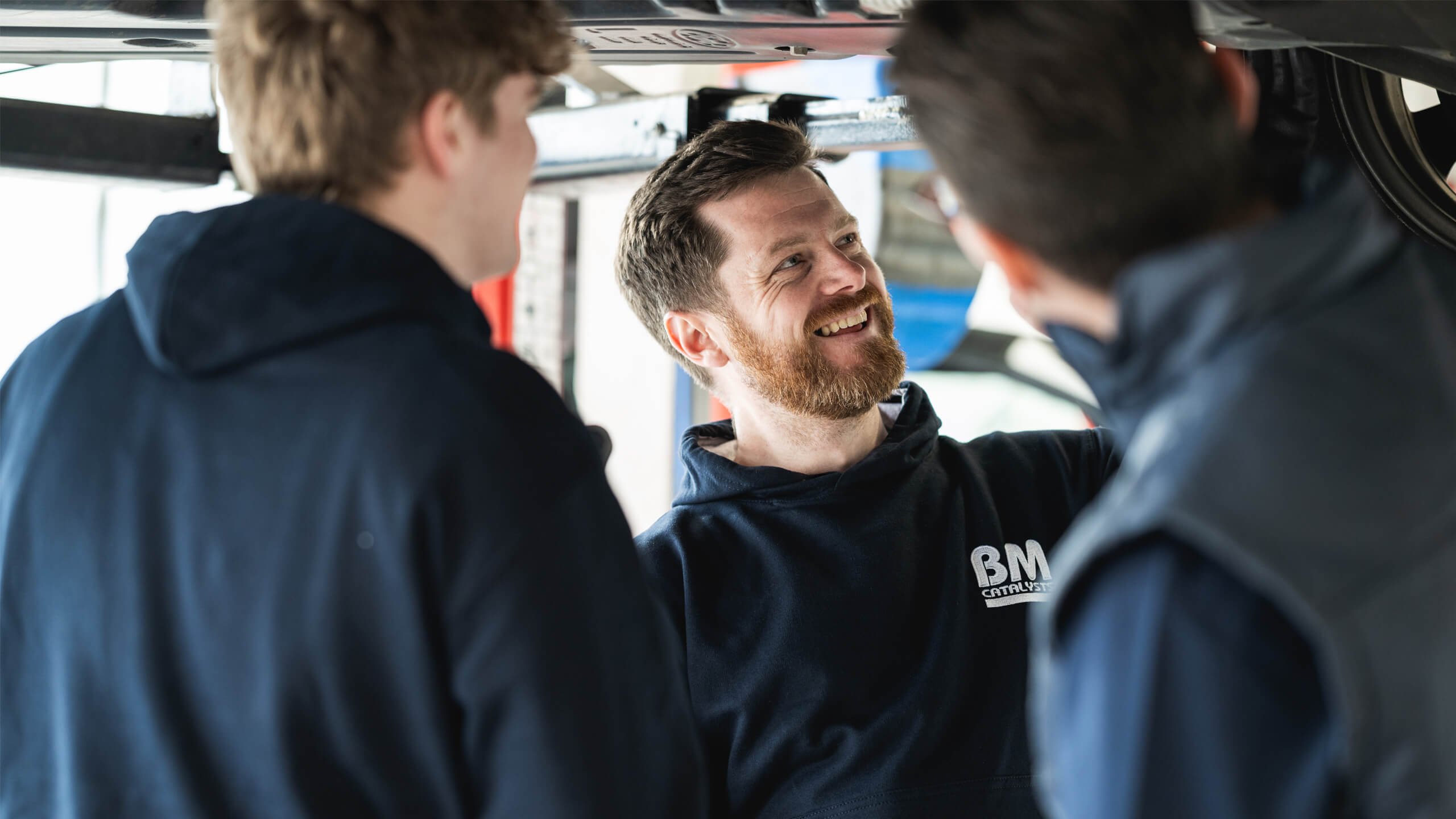 BM Garage employees looking under vehicle