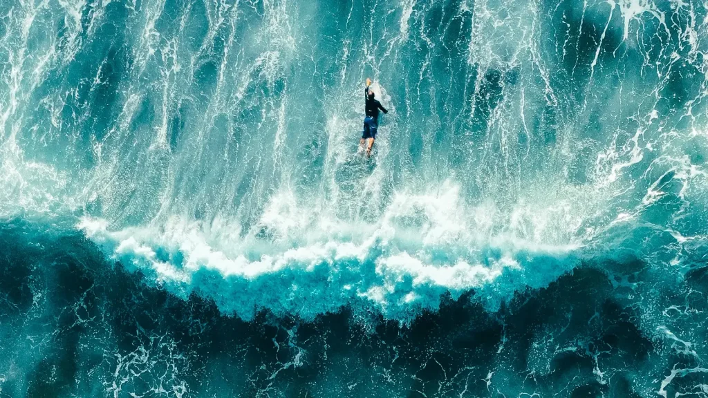 Surfer in deep blue sea.