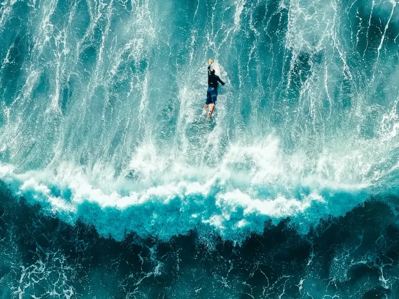 Surfer in deep blue sea